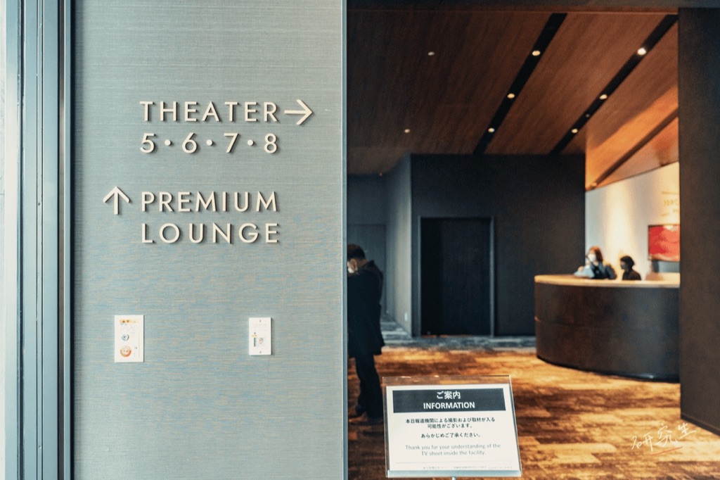 指向 THEATER 與 PREMIUM LOUNGE 的金屬指示牌