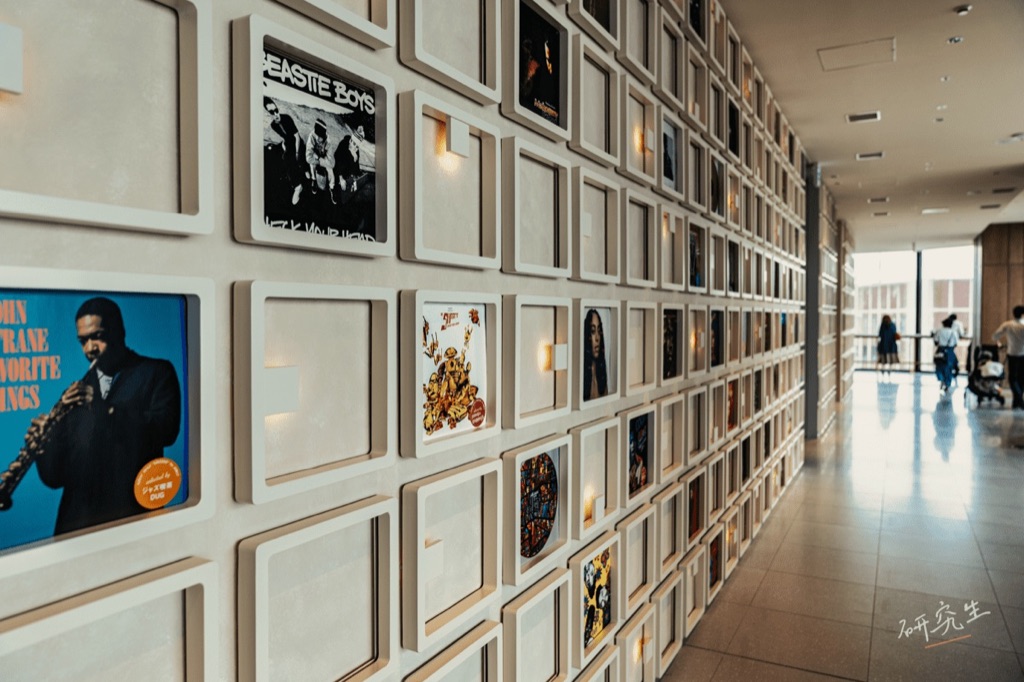 一整面牆的唱片封面展示,走廊延伸到底