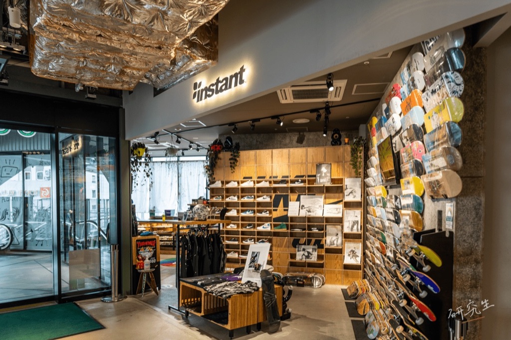 Instant 滑板店的店面，整面牆掛滿了滑板