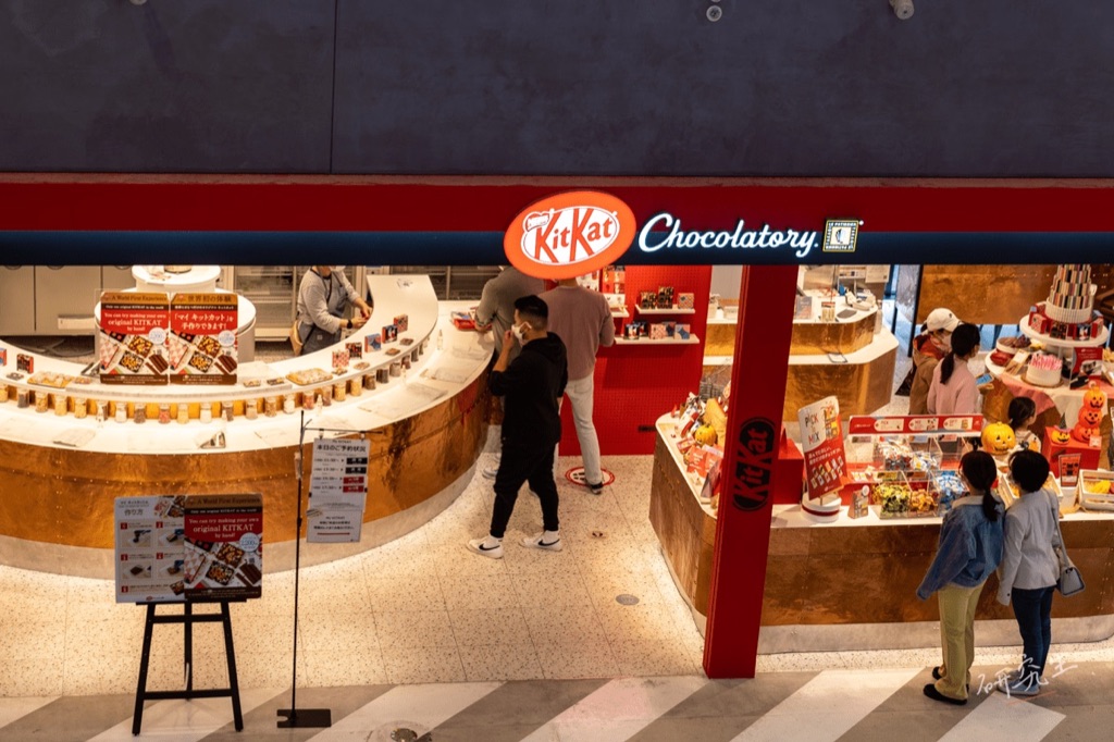 KITKAT Chocolatory 的店面，紅色招牌下是弧形的商品陳列檯