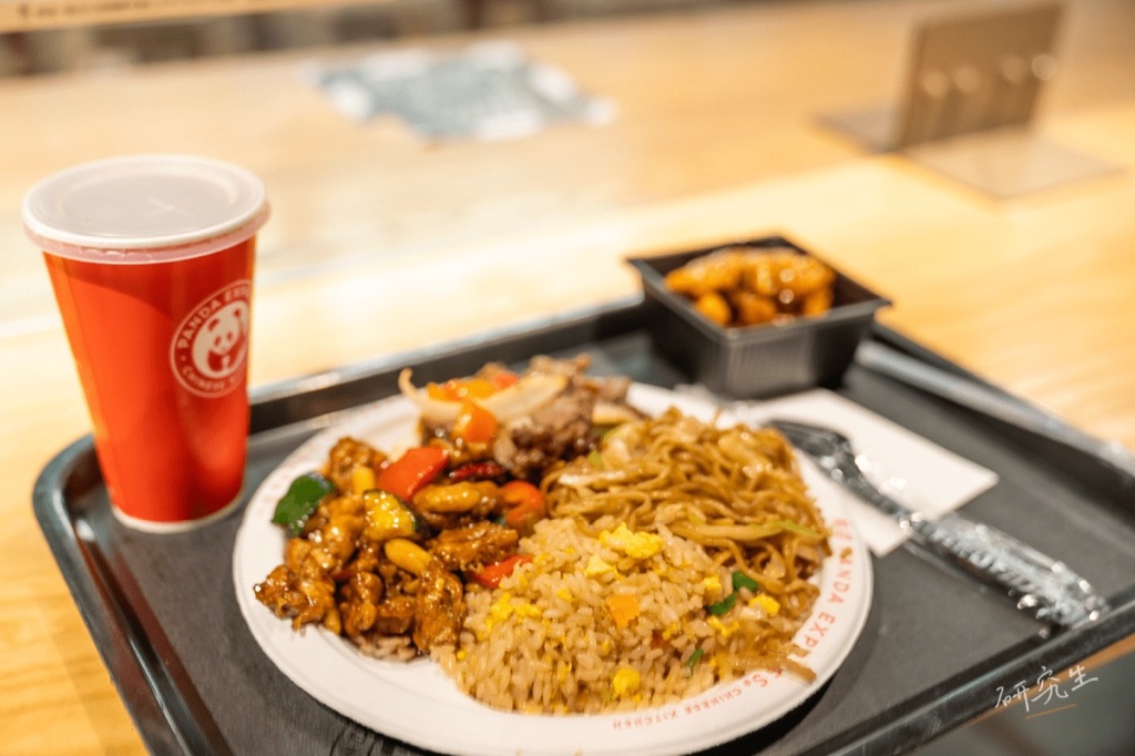 PANDA EXPRESS 的餐盤，炒飯、炒麵、橘雞配一杯紅色紙杯飲料